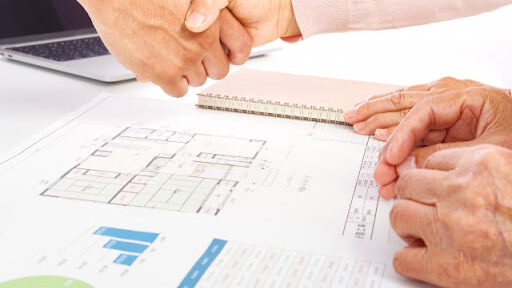 リノベーション業者と顧客が握手をしている