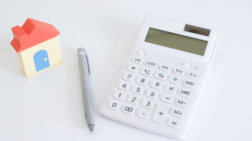 費用を計算する道具　電卓　ペン　家の模型