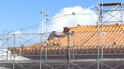 業者の人２人が屋根の工事を行っている