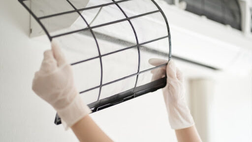 エアコンのカバーを開けて異常がないか確認している