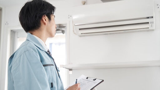 修理業者がエアコンの点検をしている