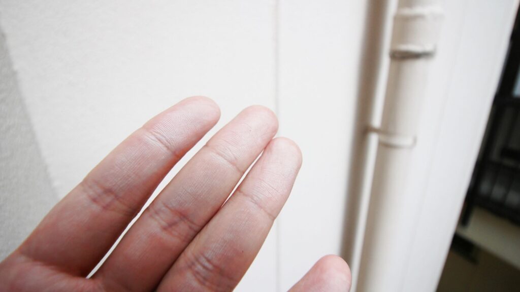 外壁を触ると粉状になった塗料が付いている(チョーキング現象)